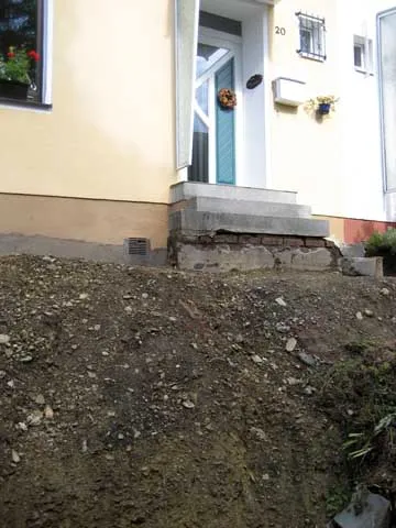 Rohbauphase einer massiven Blockstufentreppe im unbefestigten Hanggelände vor dem Wohnhaus