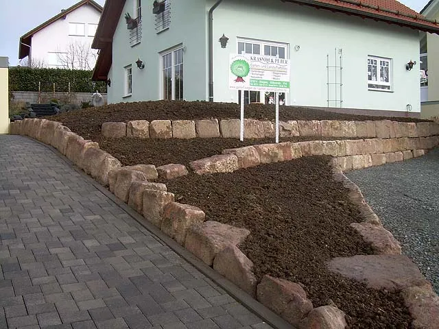 Terrassierter Vorgarten mit Sandstein-Staffelmauern und Kiesweg
