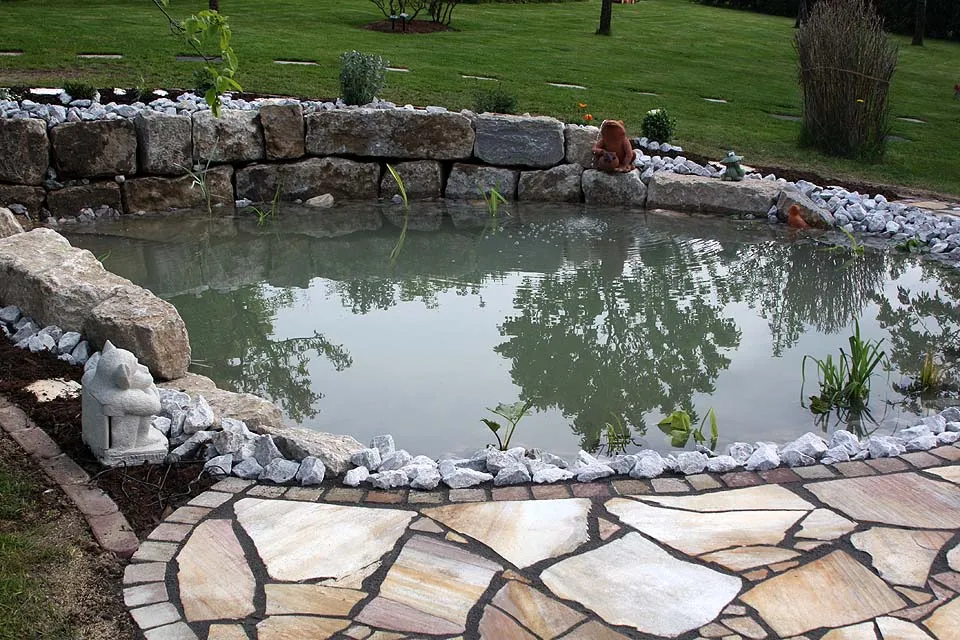 Naturnah angelegter Gartenteich mit standfester Natursteineinfassung und Uferbepflanzung